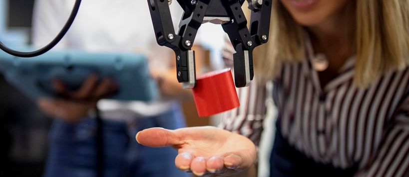 A robot dropping a red block on a woman’s palm. Image by: Terho Aalto 